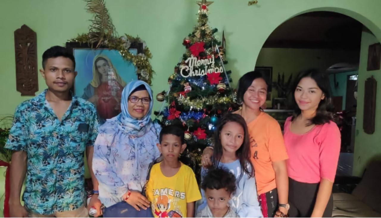 Foto keluarga di depan pohon Natal